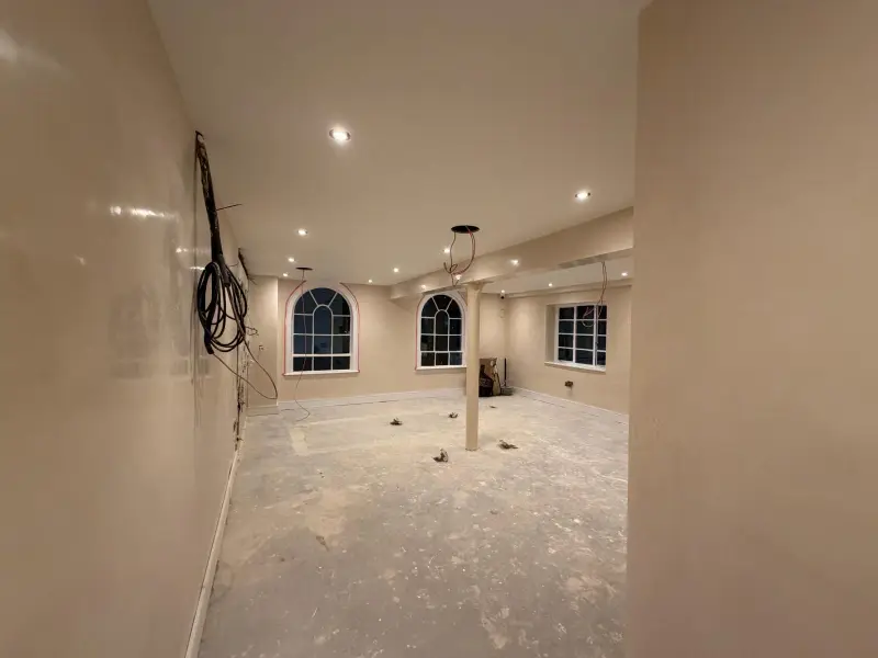 Large basement room with polished cream Venetian plaster walls and arched windows