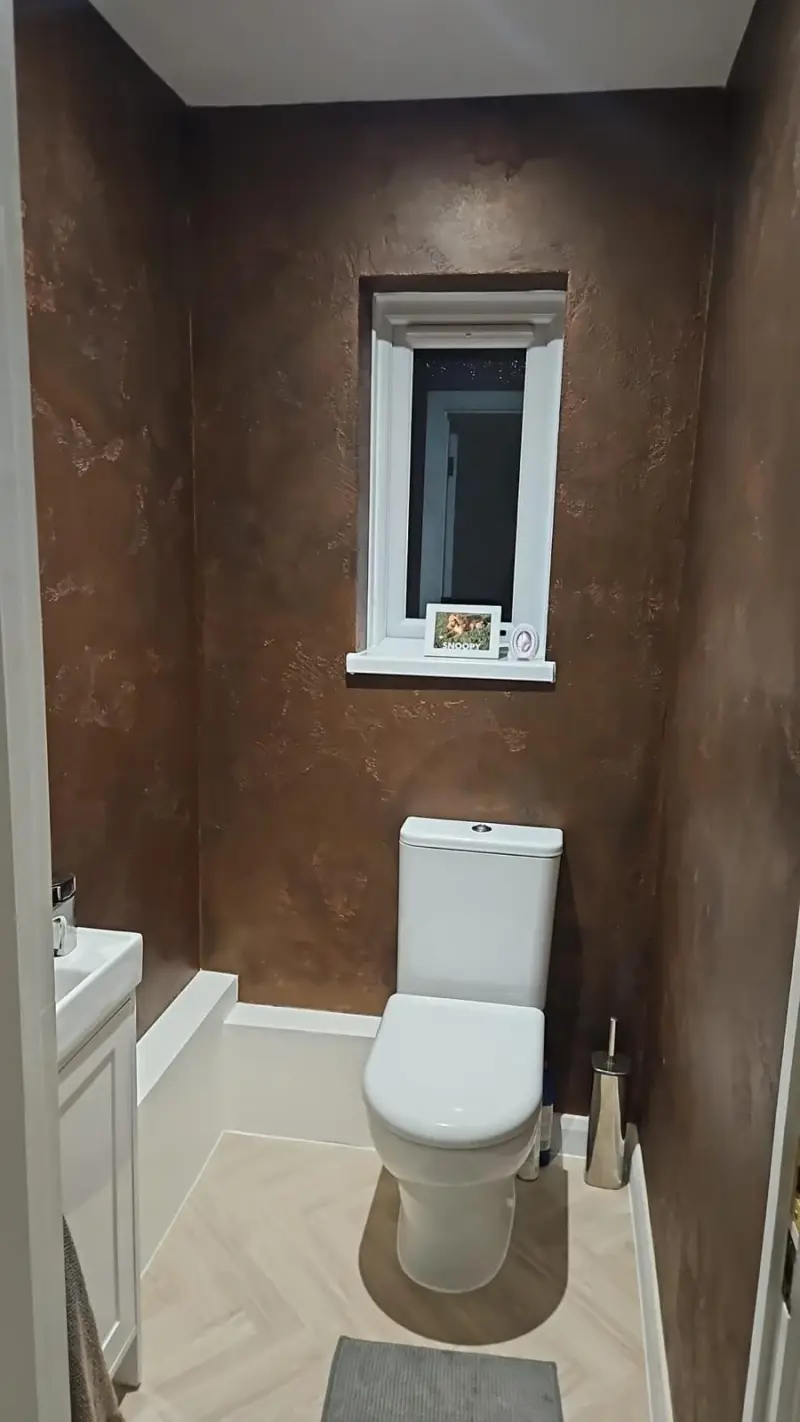 Cloakroom with rich bronze metallic Venetian plaster walls around a small window