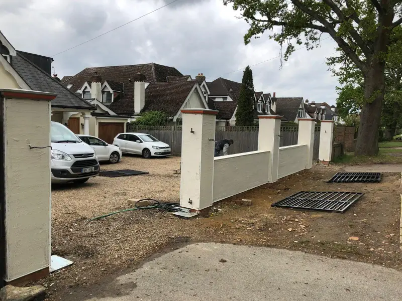 Front boundary wall and gate pillars with fresh cream render base coat